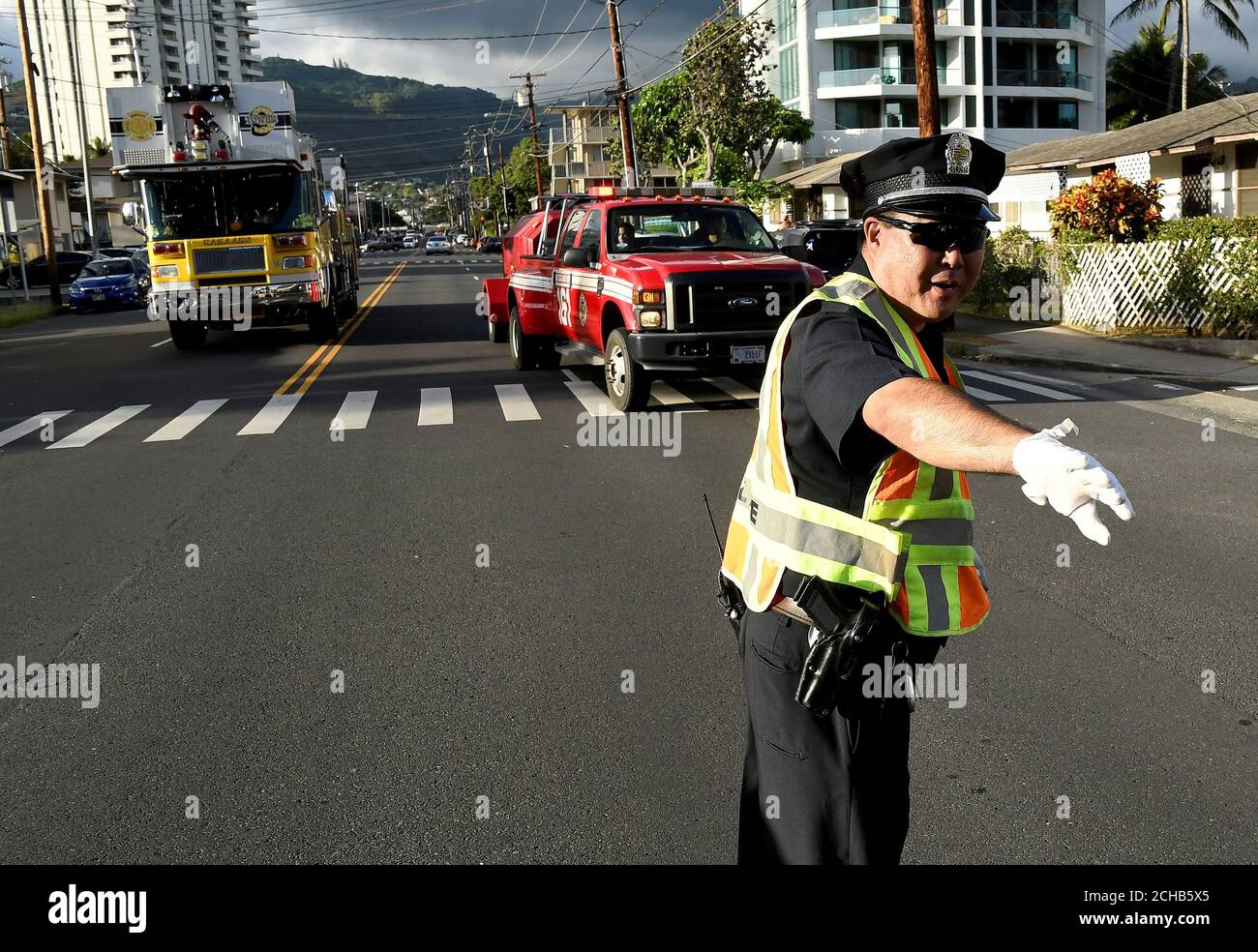 A police officer directs a fire truck to the Marco Polo apartment building  after a fire broke out in it in Honolulu, Hawaii, July 14, 2017.  REUTERS/Hugh Gentry Stock Photo - Alamy