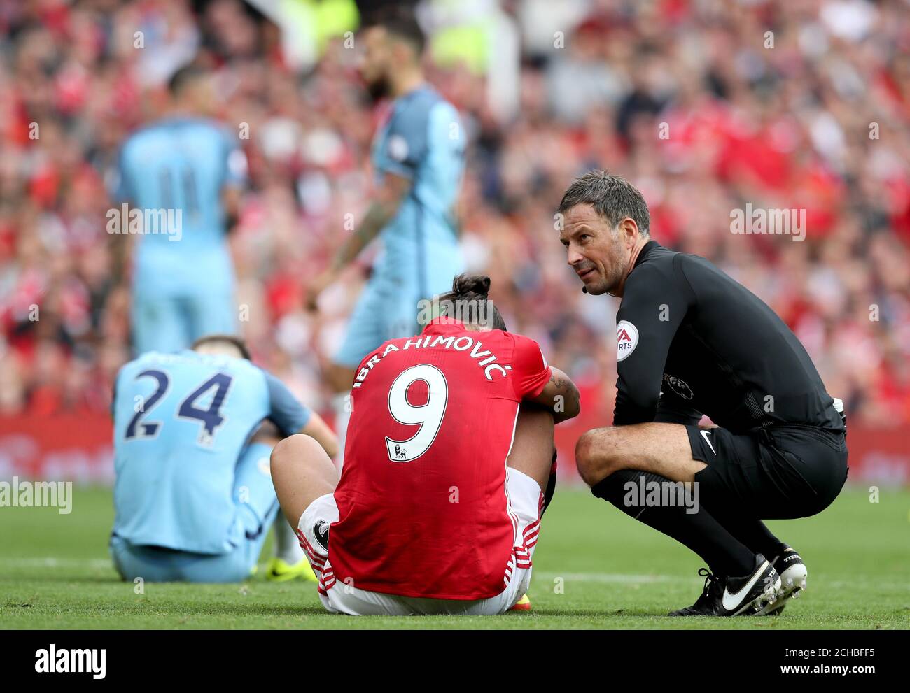 Referee Mark Clattenburg (right) crouches to check on Manchester United's  Zlatan Ibrahimovic during the Premier League match at Old Trafford,  Manchester. PRESS ASSOCIATION Photo. Picture date: Saturday September 10,  2016. See PA