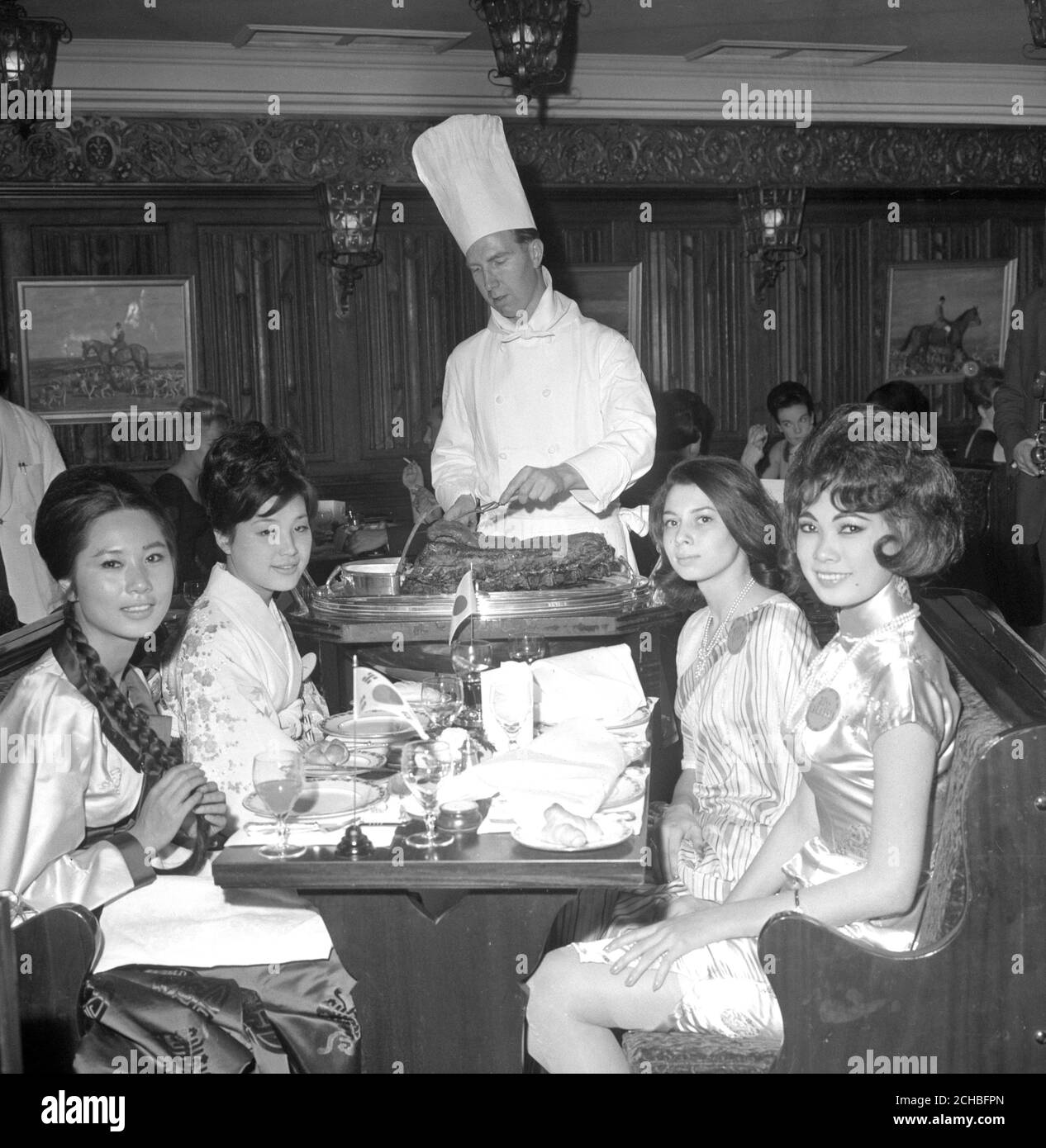 Miss World contestants sample a roast beef dish served by chef Barry Crossley at the Baron of Beef restaurant in Gutter Lane, London. (l-r) Miss Korea Keum-Shil Choi, 22, Miss Japan Miyako Harada, 20, Miss Ceylon Jennifer Fonseka, 18, and Miss Malaysia Catherine Loh, 19. Stock Photo