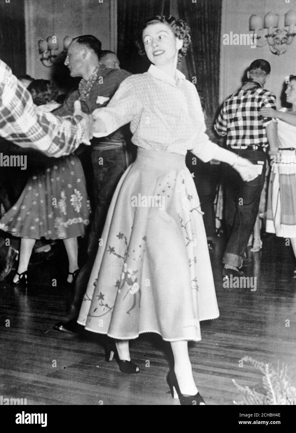Princess Elizabeth square dancing at the Governor General's residence at Rideau Hall, Ottawa, during her tour of Canada. In background wearing a check shirt is Prince Philip. Stock Photo