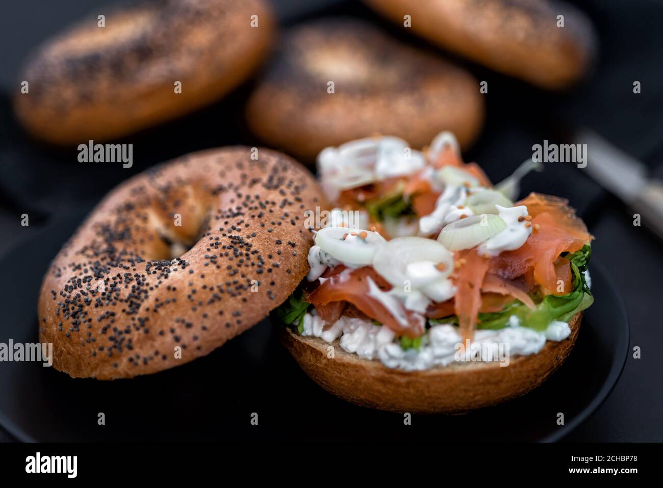 Salmon Lox Bagel with cream cheese and veggies on a dark setting Stock