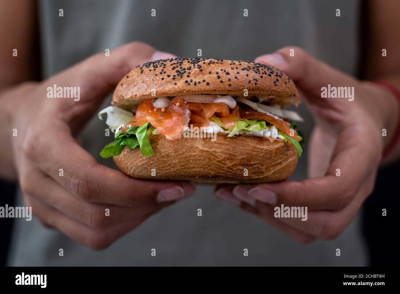 Woman holding a lox bagel with cream cheese and veggies Stock Photo Alamy