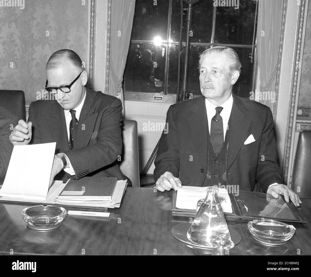 Sir Norman Brook, Secretary of the Cabinet, goes through his papers alongside Harold Macmillan before the opening of today's session of the Commonwealth Prime Ministers' Conference at Marlborough House, London. Stock Photo