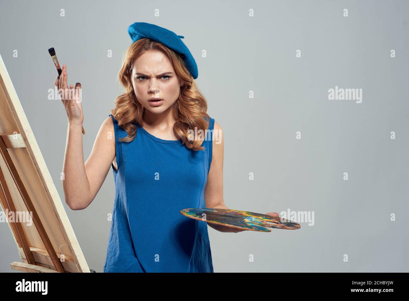 woman artist blue beret palette drawing on easel art creativity light ...