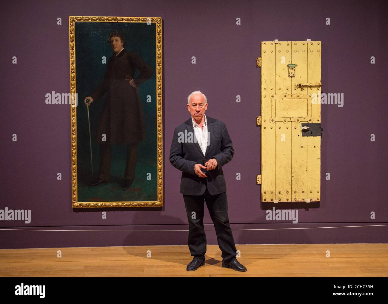 Actor Simon Callow with 'Oscar Wilde' by Robert Goodloe Harper Pennington (left) and Oscar Wilde's prison door from Reading Gaol, during a photo call at the Tate Britain in London for their Queer British Art 1861 -1967 exhibition. Stock Photo