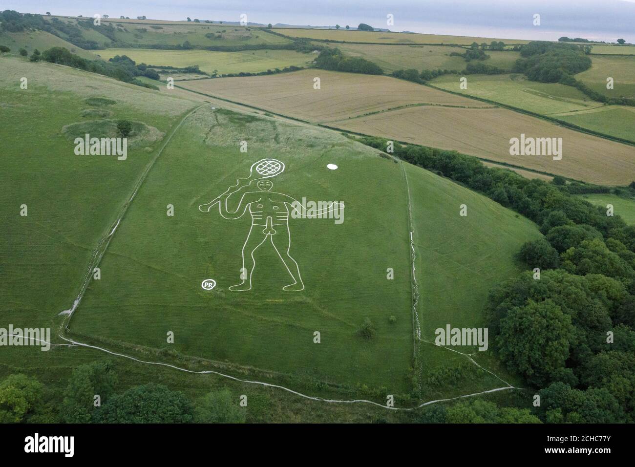 An aerial view of the 180ft Cerne Abbas Giant in Dorset, holding a tennis racket and a new set of balls, which bookmaker Paddy Power added to mark the start of the Wimbledon tennis tournament. Stock Photo