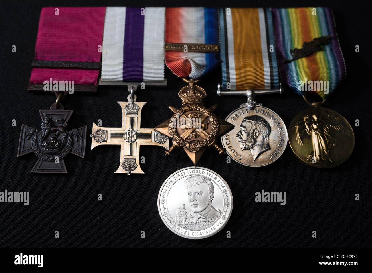 A commemorative £5 coin, which honours First World War hero Captain Noel Chavasse, unveiled by The Royal Mint at the Imperial War Museum in London, alongside his Victoria Cross that is part of the Lord Ashcroft collection. Stock Photo