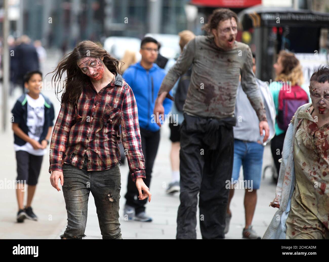 EDITORIAL USE ONLY People dressed as zombies interact with passers-by in Shoreditch, London, to mark the arrival of two new The Walking Dead scare mazes at Thorpe Park Resort for its annual Fright Nights season launching at the Surrey theme park on September 29th.  Stock Photo