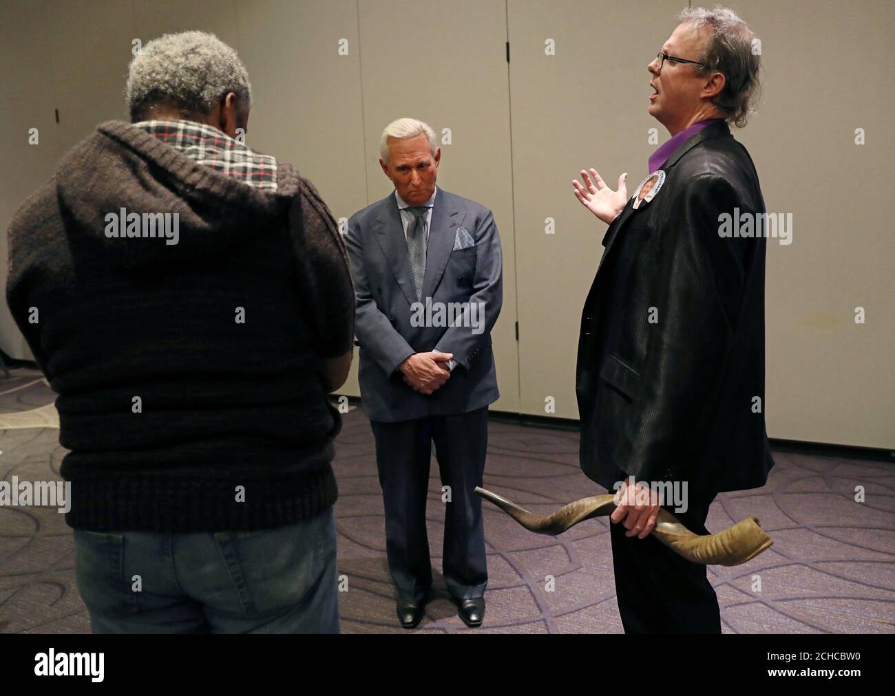 Johnny Rice (R) and Dr. Randy Lancaster Short pray over Roger Stone,  longtime ally of U.S. President Donald Trump, after he appeared for a press  conference and interviews with media in Washington,