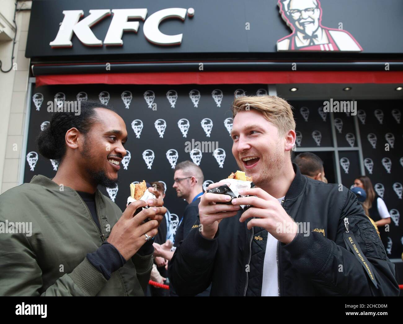 EDITORIAL USE ONLY Customers Dayle Witter (left) and Liam Bagnall try the 'Double Down', which is a bun-less burger that features two Original Recipe chicken fillets, and will be on sale in the UK for 6 weeks only from October 9th, outside a branch of KFC in Gloucester Road in London Stock Photo