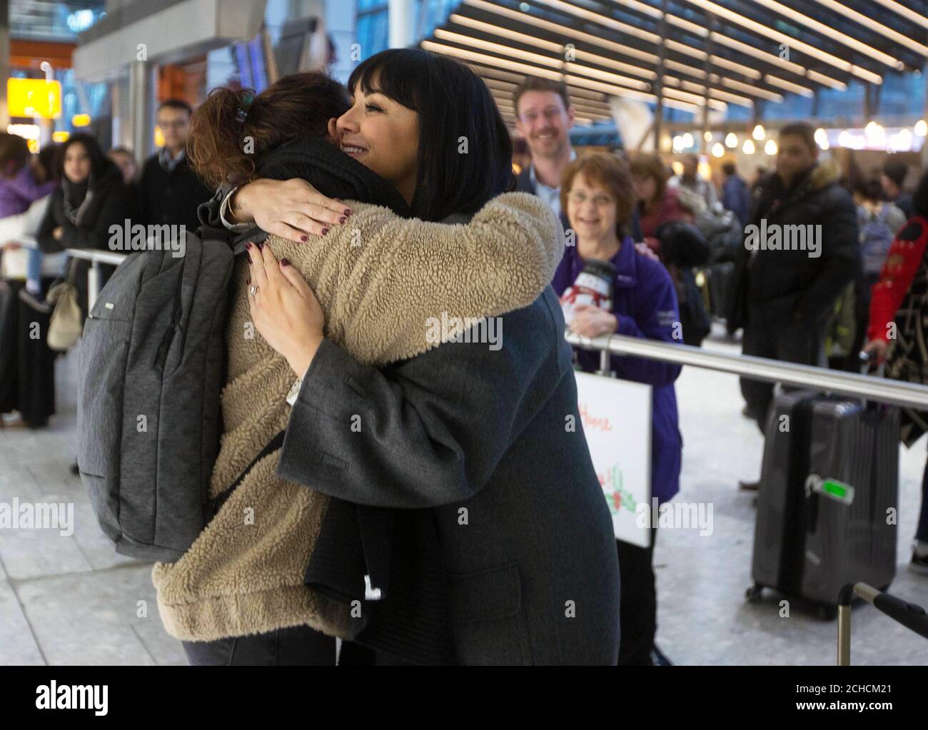 EDITORIAL USE ONLY Martine McCutcheon (right) joins volunteers at Heathrow Airport to welcome home passengers for Christmas with their own ÔLove ActuallyÕ moment, ahead of the airportÕs busiest week for arrivals, Middlesex. PRESS ASSOCIATION. Photo. Picture date: Tuesday December 19, 2017. Family and friends can direct message @Heathrowairport on Twitter to arrange for a loved one to have a personalised welcome when they arrive into the airport if they canÕt be there in person this Christmas. Photo credit should read: David Parry/PA Wire  Stock Photo