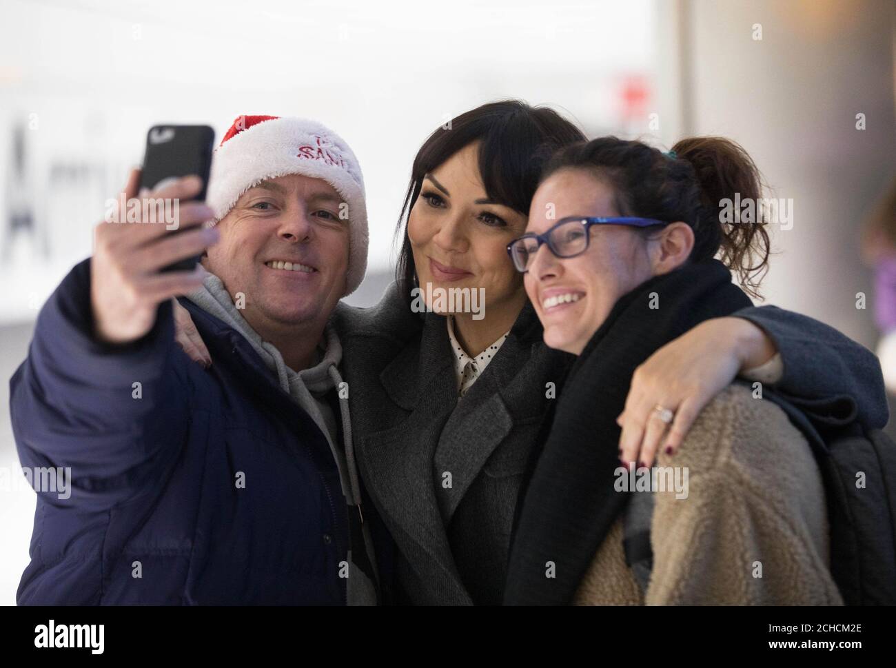 EDITORIAL USE ONLY Martine McCutcheon (centre) joins volunteers at Heathrow Airport to welcome home passengers for Christmas with their own ÔLove Actually' moment, ahead of the airport's busiest week for arrivals, Middlesex. PRESS ASSOCIATION. Photo. Picture date: Tuesday December 19, 2017. Family and friends can direct message @Heathrowairport on Twitter to arrange for a loved one to have a personalised welcome when they arrive into the airport if they can't be there in person this Christmas. Photo credit should read: David Parry/PA Wire Stock Photo