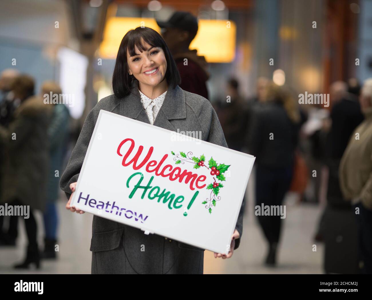EDITORIAL USE ONLY  Martine McCutcheon joins volunteers at Heathrow Airport to welcome home passengers for Christmas with their own ÔLove ActuallyÕ moment, ahead of the airportÕs busiest week for arrivals, Middlesex. PRESS ASSOCIATION. Photo. Picture date: Tuesday December 19, 2017. Family and friends can direct message @Heathrowairport on Twitter to arrange for a loved one to have a personalised welcome when they arrive into the airport if they canÕt be there in person this Christmas. Photo credit should read: David Parry/PA Wire Stock Photo