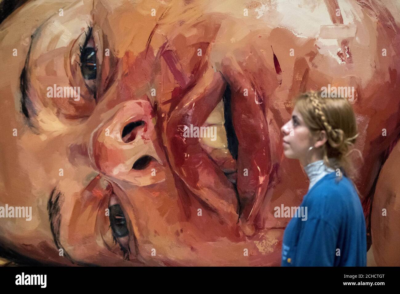A visitor looks at Jenny Saville's Reverse 2002-3 during a photocall for Tate Britain's All Too Human: Bacon, Freud and a Century of Painting Life exhibition which will showcase around 100 works by some of the most celebrated modern British artists including Lucian Freud and Francis Bacon. Stock Photo