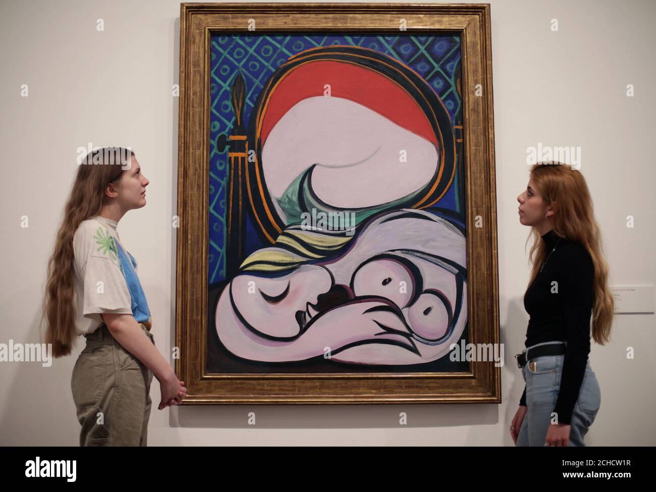 Women looking at Pablo Picasso's The Mirror, 1932, during a preview of the exhibition Picasso 1932 - Love, Fame, Tragedy at Tate Modern in London. Stock Photo