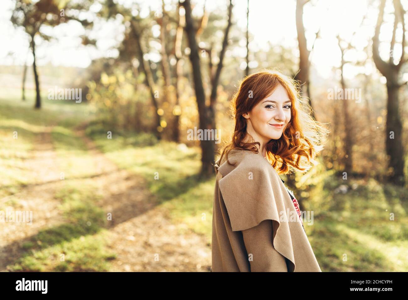 Pretty and happy red hair girl walking in the forest Stock Photo - Alamy