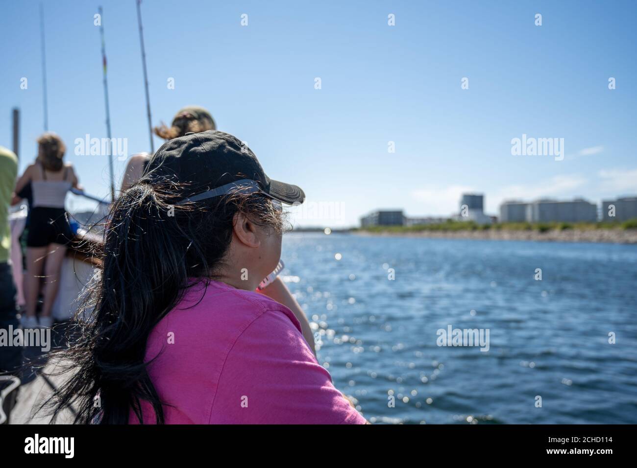 Malmo, Sweden - August 6, 2020: A middle-aged Asian woman on a boat trip a hot summer day. Bright blue sky and ocean in the background Stock Photo