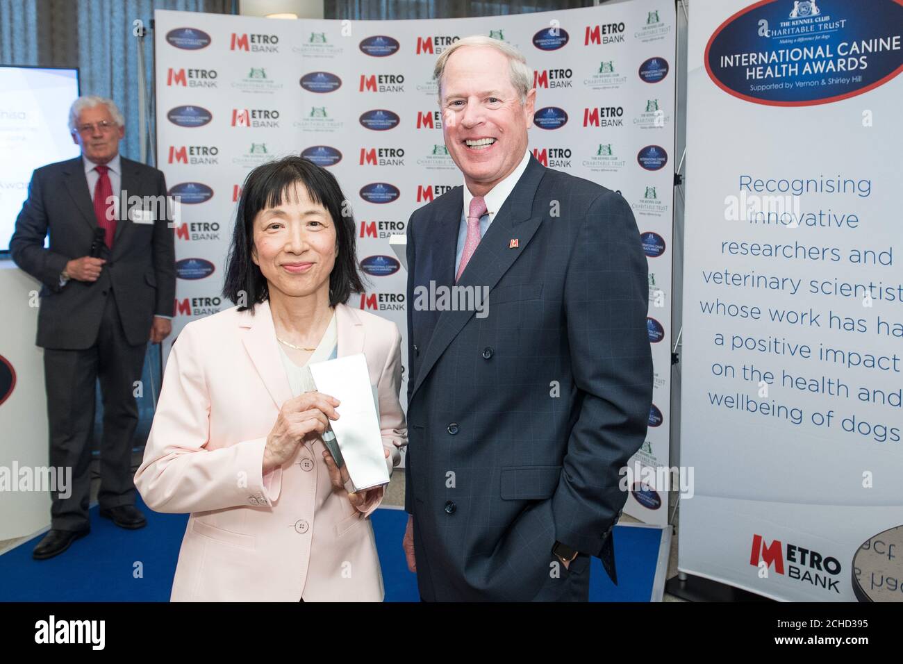 Dr Yasuko Rikihisa from the College of Veterinary Medicine Ohio State University, receives the International Award from Vernon Hill, founder of Metro Bank, during the International Canine Health Awards at the Kennel Club, London. Stock Photo