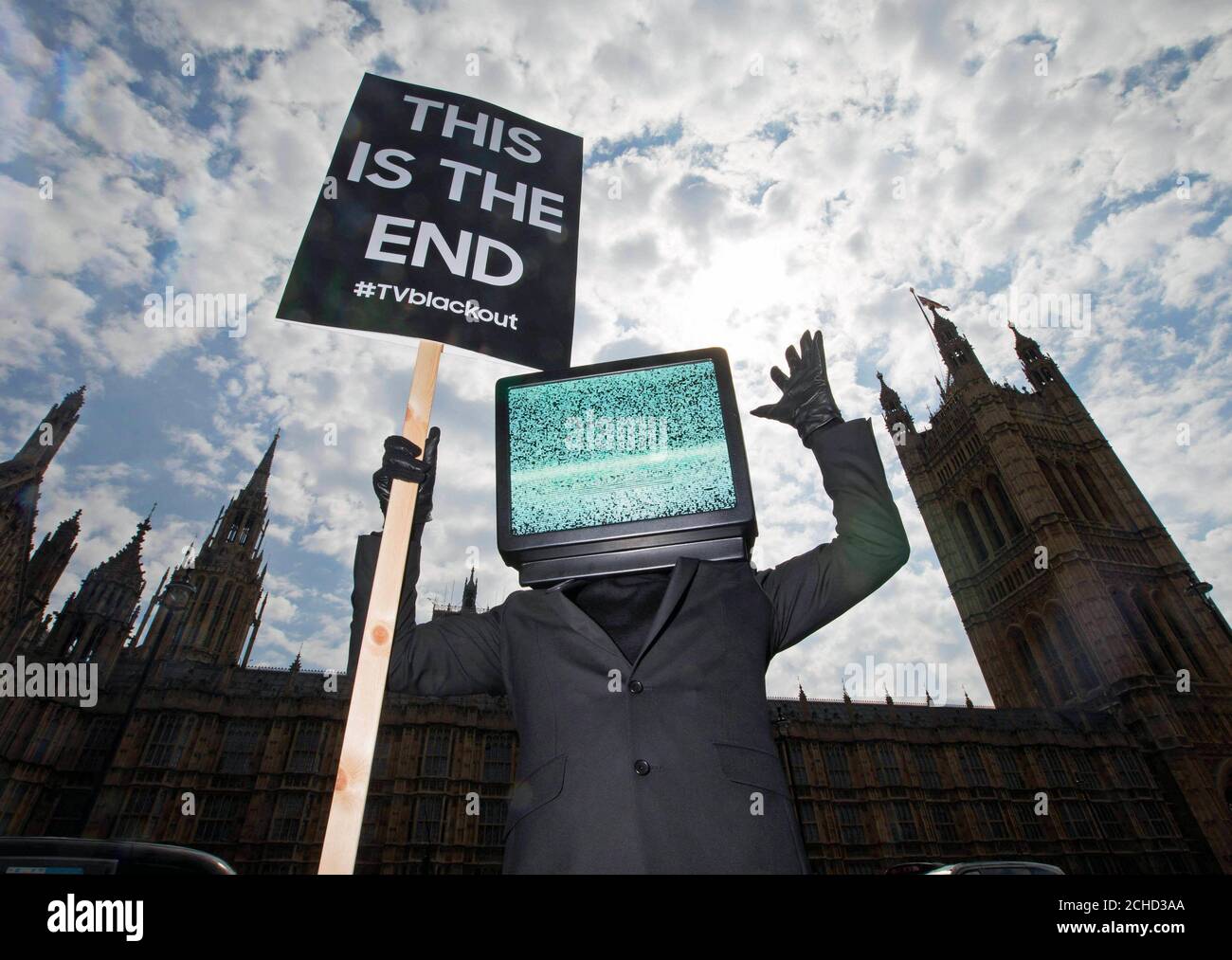 EDITORIAL USE ONLY A person with a TV head holds a 'This is the End' protest sign in Westminster, London, as part of a campaign by Samsung to launch their new QLED TV range.  Stock Photo