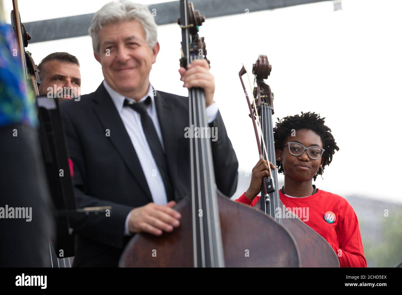 Sir Simon Rattle conducts the London Symphony Orchestra with 50 LSO On Track young musicians from across East London and Guildhall School musicians at BMW Classics in Trafalgar Square, London. Stock Photo