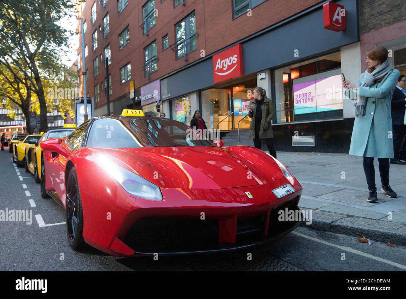 EMBARGOED TO 0001 TUESDAY OCTOBER 2 EDITORIAL USE ONLY A Ferrari 488 Spyder  lines up outside Argos, alongside an Audi R8 V10 Plus Spider and a  Lamborghini Aventador, waiting to chauffeur home