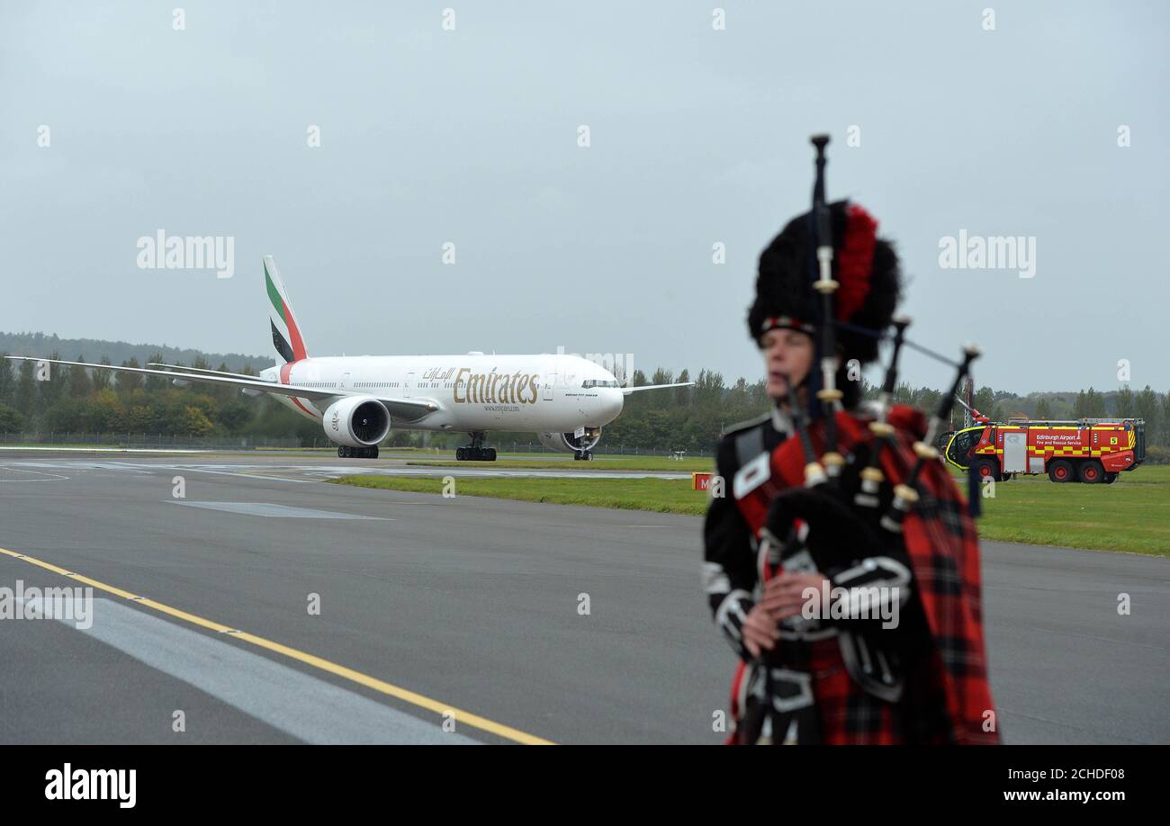 An Emirates Boeing 777-300ER is met by a piper at Edinburgh Airport as the airline launches a new route linking Dubai and Scotland's capital city. Stock Photo