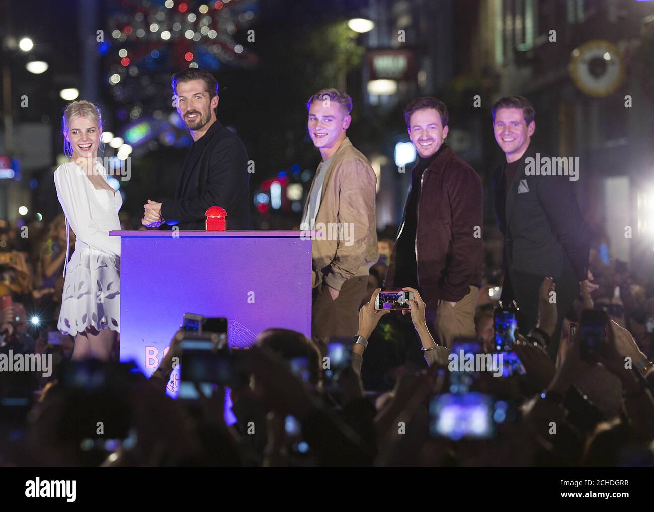 Cast members of the Bohemian Rhapsody film (left to right) Lucy Boynton, Gwilym Lee, Ben Hardy, Joe Mazzello and Allen Leech at the official launch of a light installation celebrating the Queen song at Carnaby Street in London. The lights featuring Freddie Mercury's lyrics will illuminate the street until January, in honour of the upcoming movie. Stock Photo