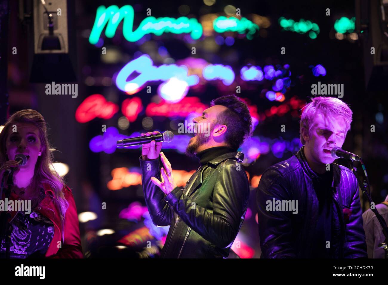 EDITORIAL USE ONLY Bulsara and His Queenies, Official Queen tribute band perform on stage below the Bohemian Rhapsody lights as Christmas launches on Carnaby Street, London. Stock Photo