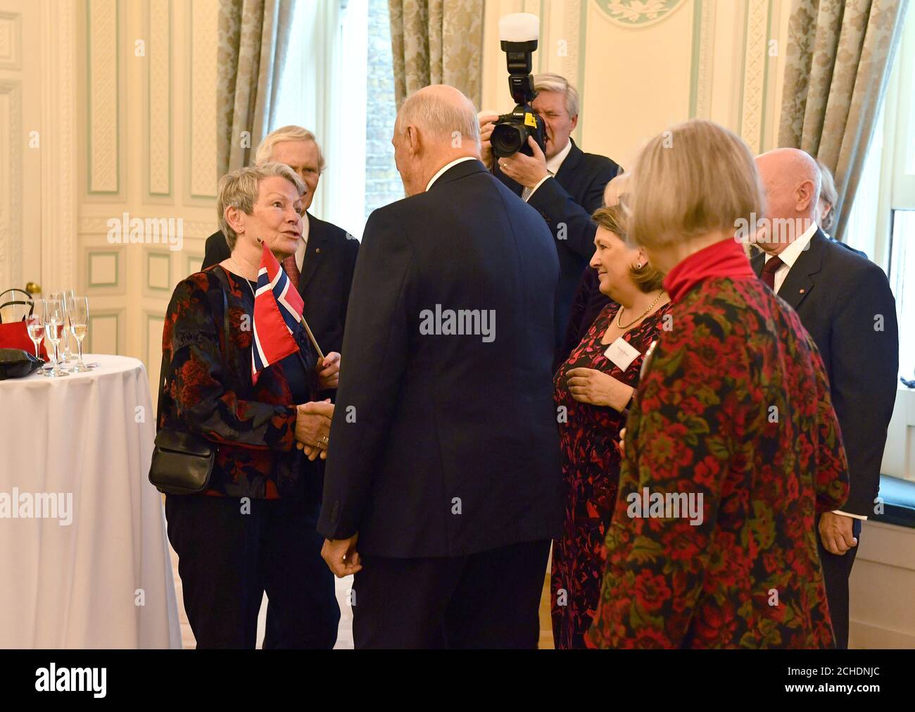 King Harald V of Norway meets guests at the Anglo-Norse Society centenary reception at the Naval and Military Club in central London. Stock Photo