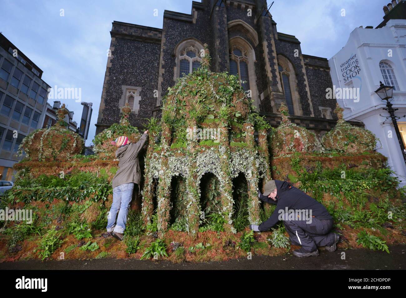 Plant expert,Tomoko O'Reilly (left) and Iain Prendergast put the finishing touches to a 12ft tall replica of the Brighton Pavilion made from plants, created by Seventh Generation and Plantlife on display in Brighton to encourage people to sign an online petition calling on Government to invest more in plant-based solutions to combat climate change. Stock Photo