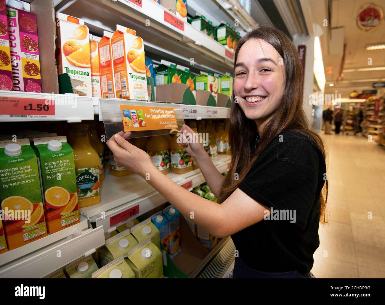 Amber Broad places a 'priority item' label next to goods at Sainsbury's in Exeter to highlight to customers which products are most needed for the in-store charity donation box, as a group of teenagers taking part in the National Citizen Service (NCS) came up with the idea as part of the social action phase of the national programme. Stock Photo