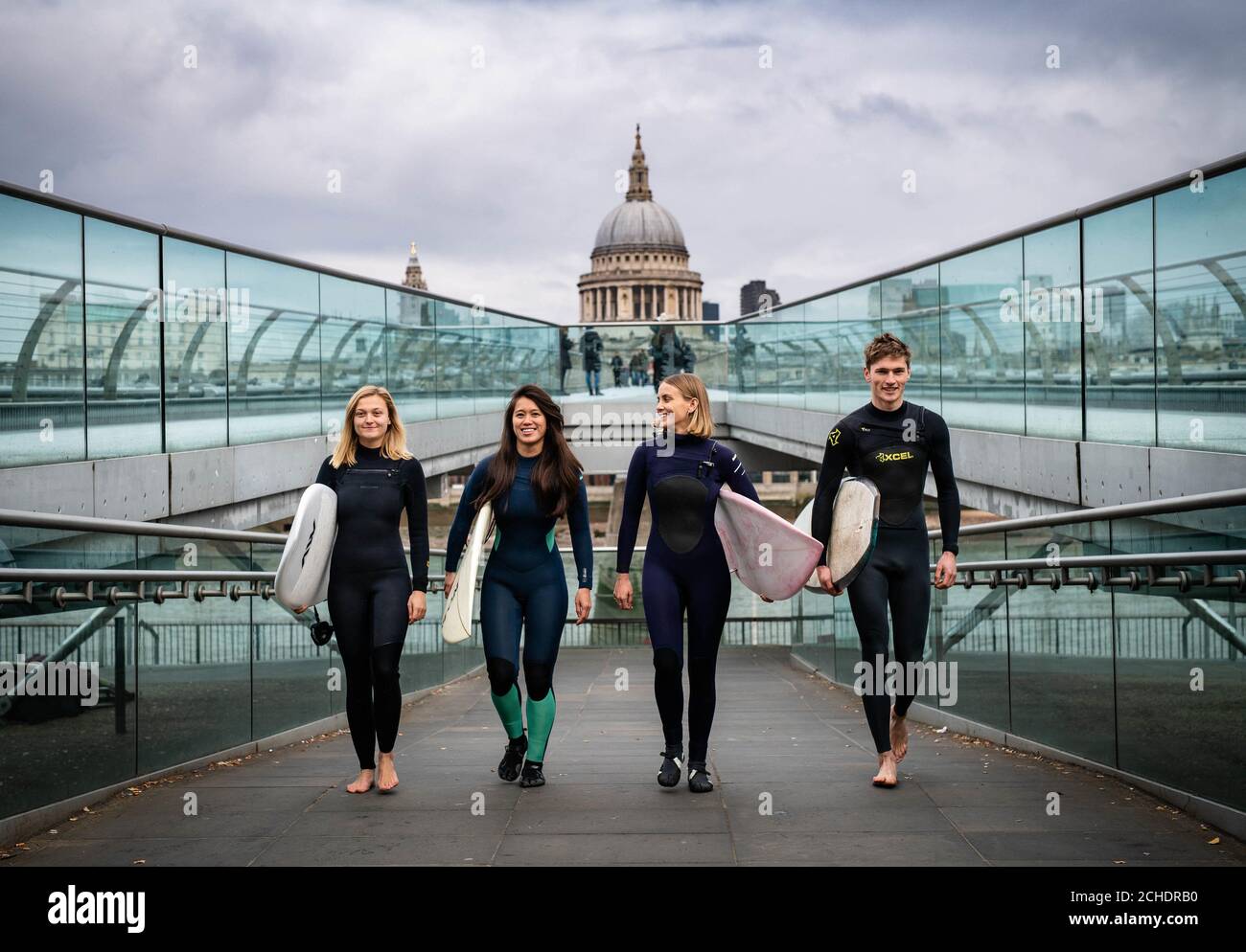 EMBARGOED TO 0001 TUESDAY NOVEMBER 27  EDITORIAL USE ONLY  (Left to right) Surfers Jessica Rowe, Veranika Lim, Sophie Hellyer and Frank Hodgson cross London's Millennium Bridge as a partnership is announced between Lee Valley Regional Park Authority and The Wave to create an inland surfing destination in the capital for people of all ages, backgrounds and abilities. Stock Photo