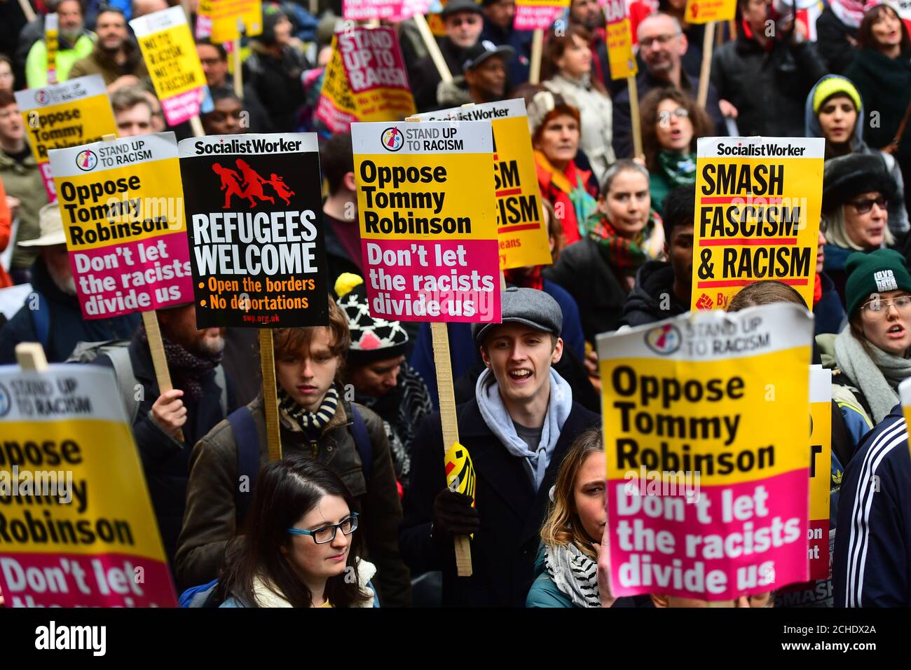 People hold placards opposing Tommy Robinson as they take part in an anti-fascist counter-demonstration against a 'Brexit Betrayal' march and rally organised by Ukip in central London. Stock Photo