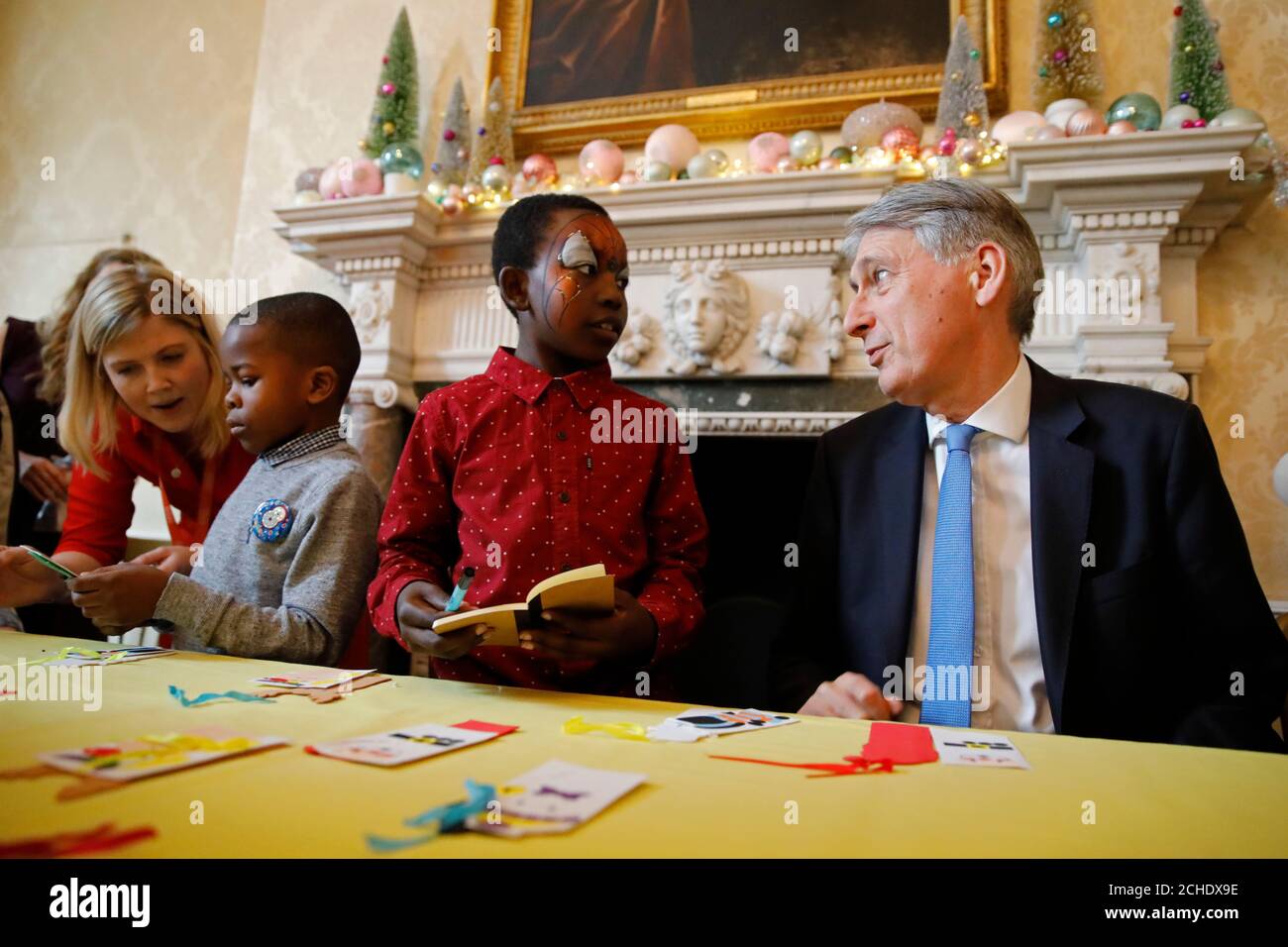 Chancellor Philip Hammond chats with a guest at a Christmas party for the Starlight Children's Foundation at 11 Downing Street, London. Stock Photo
