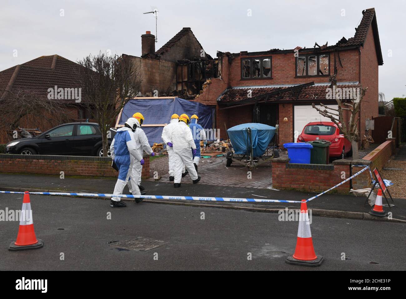 Investigators at the scene following a house fire in Peartree Road, Kirton, near Boston, in Lincolnshire, where police have launched a domestic-related murder investigation after three people were found dead after the New Year's Day fire. Stock Photo