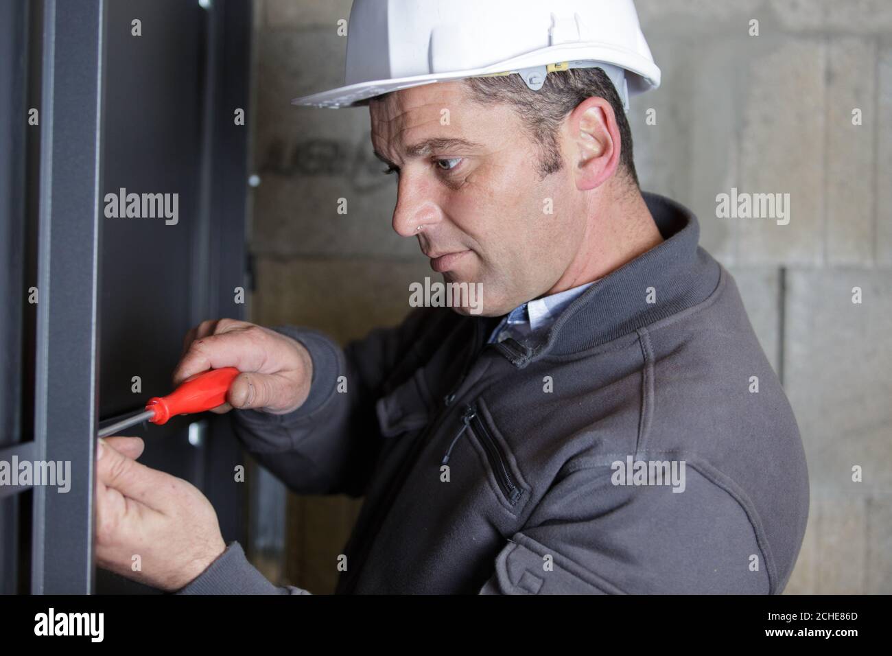 man assembles profile metal frame Stock Photo