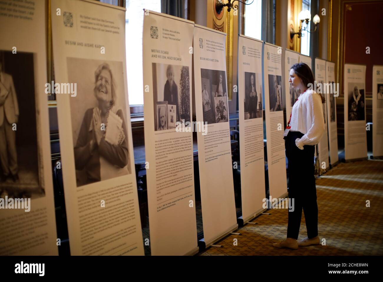 An attendee looks at panels showing life-histories of Holocaust victims at the annual Holocaust Memorial Day Commemoration event at the Foreign & Commonwealth Office, London. Stock Photo