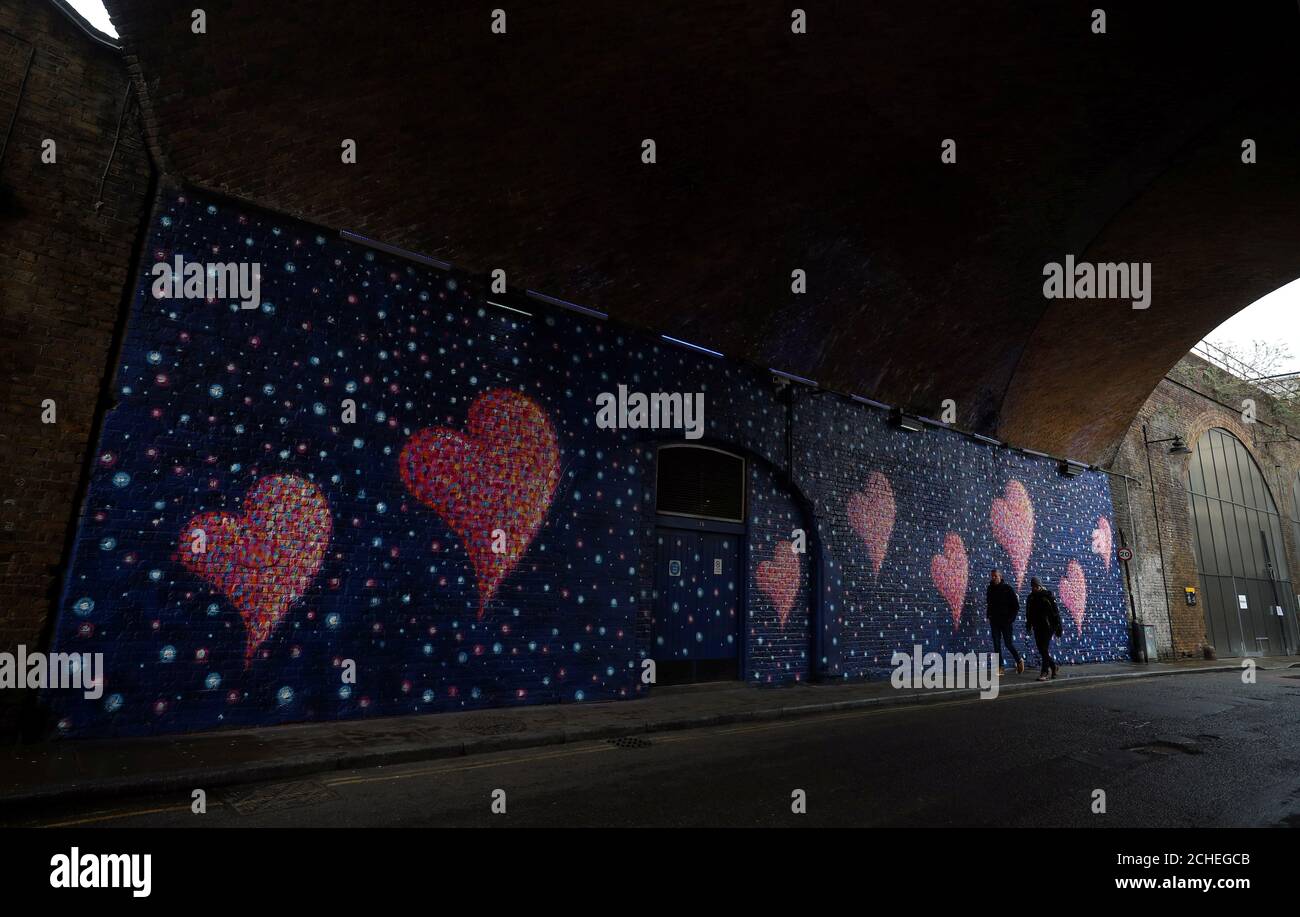 People walk past a mural, by British-born Australian artist James Cochran, painted to commemorate the victims of the London Bridge attack, in London, Britain, April 2, 2018. REUTERS/Hannah McKay Stock Photo