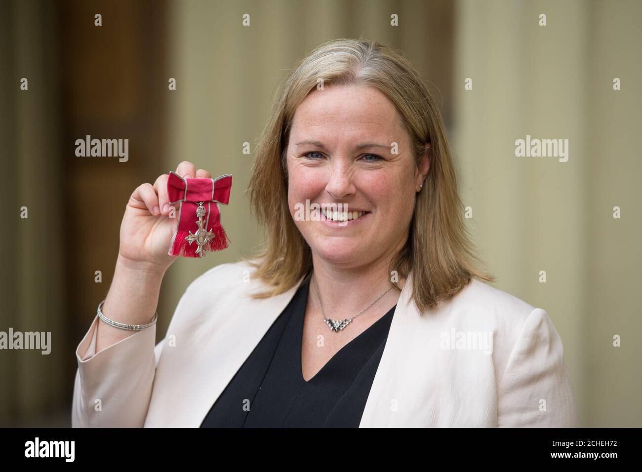 Claire O'Hara holds her MBE medal awarded to her during an investiture  ceremony at Buckingham Palace, London Stock Photo - Alamy