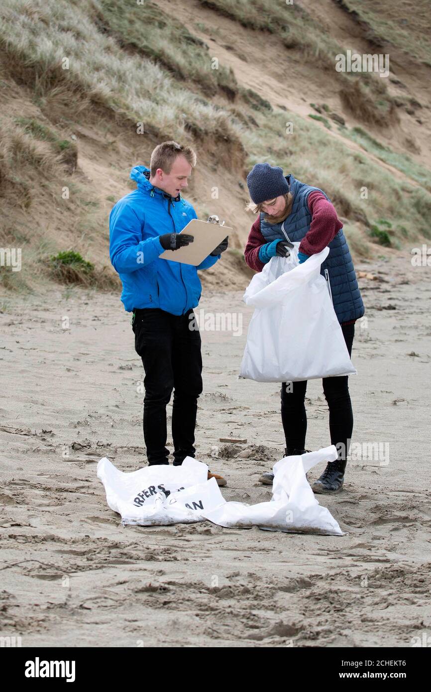 Campaigners from UK marine conservation charity Surfers Against Sewage, (left to right) Harry Dennis and Rachel Yates are calling for volunteers across the UK to help clean up the nations beaches, mountains, streets and waterways, and keep them clear of plastic, in Perranporth, Cornwall. Stock Photo