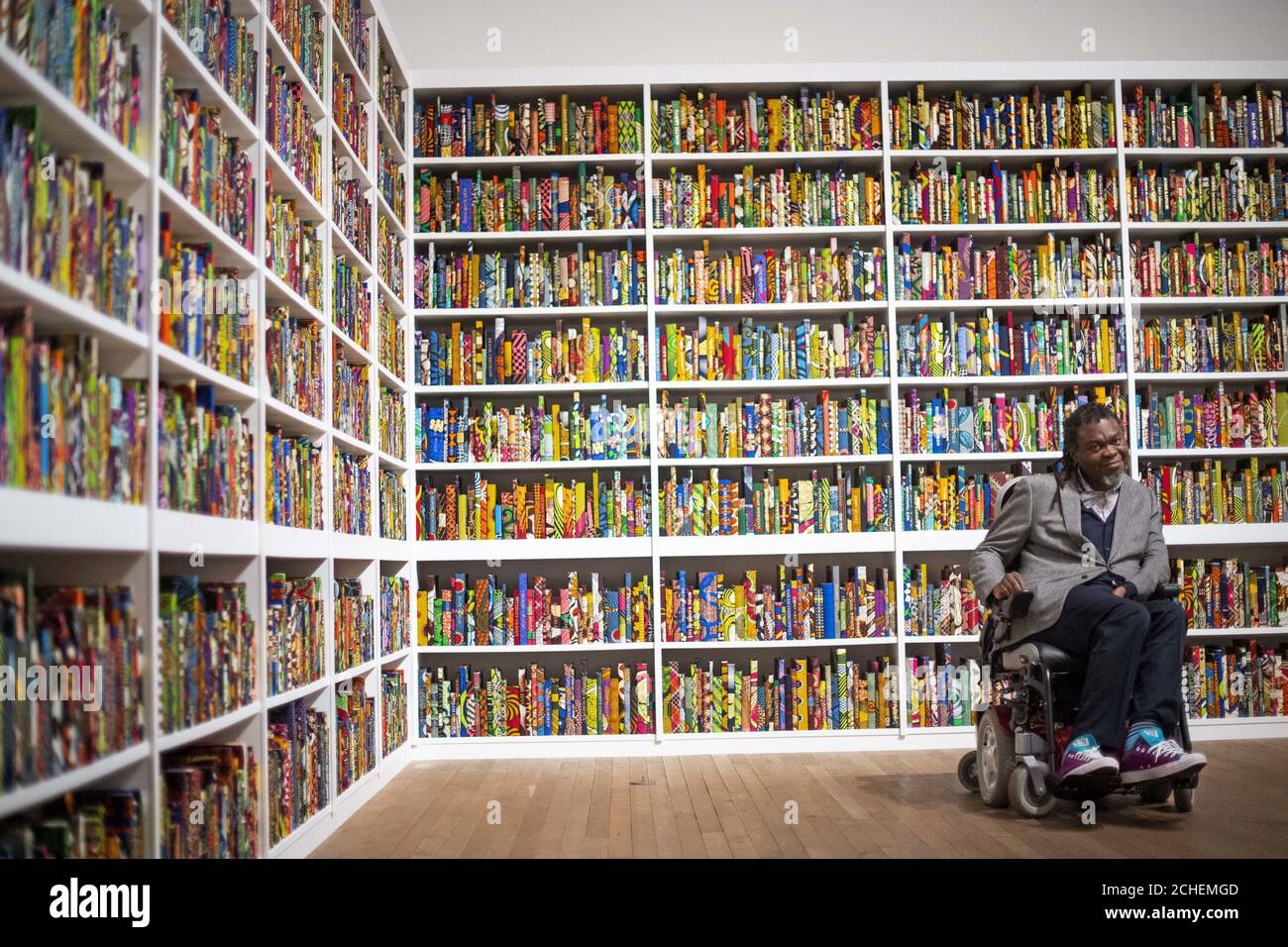 Yinka Shonibare with his work, The British Library, at Tate Modern, London, the latest artwork to be acquired by Tate. Stock Photo