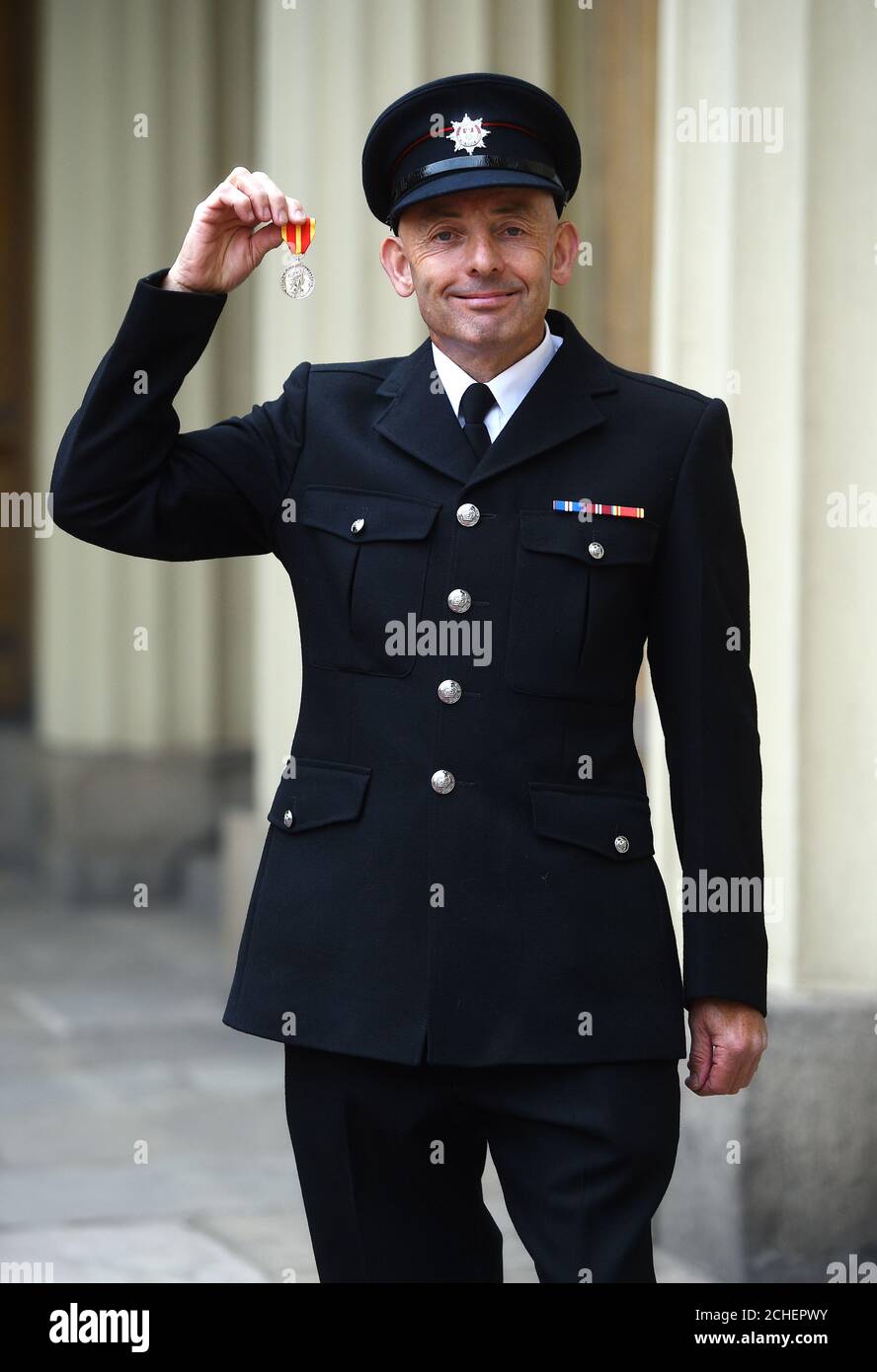 Firefighter Kevin Taylor with the Queen's Fire Service Medal after an investiture ceremony at Buckingham Palace, London. Stock Photo