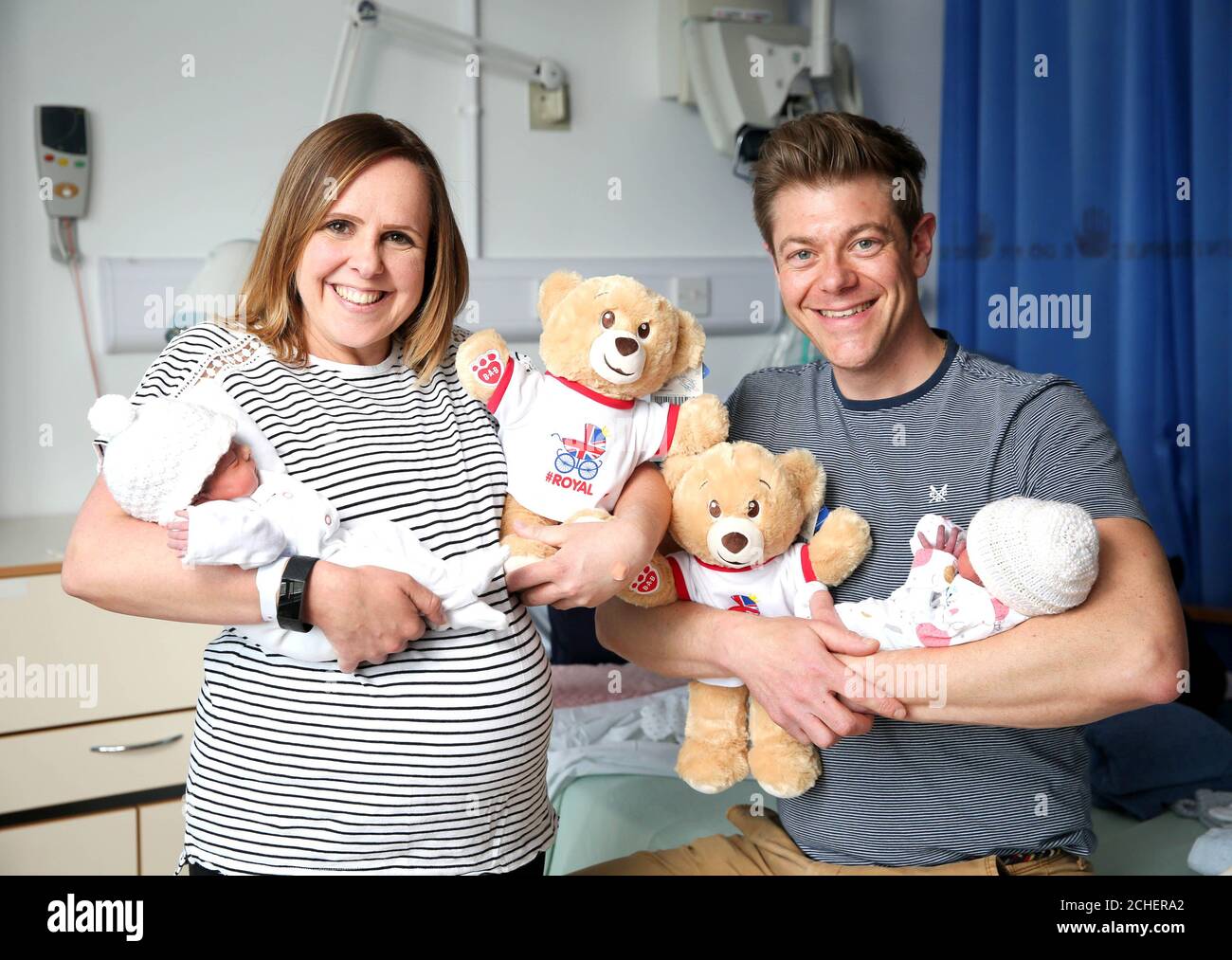 Carmen and Michael Barrett from Petersfield, with their daughters Sienna Rose (left) and Ava Grace and a toy bear at the Royal Surrey County Hospital in Guildford as the Build-A-Bear workshop celebrates the historic birth of the latest royal by delivering 1,000 bears to new-borns at 10 royal hospitals, infirmaries and maternity units across the UK. Stock Photo
