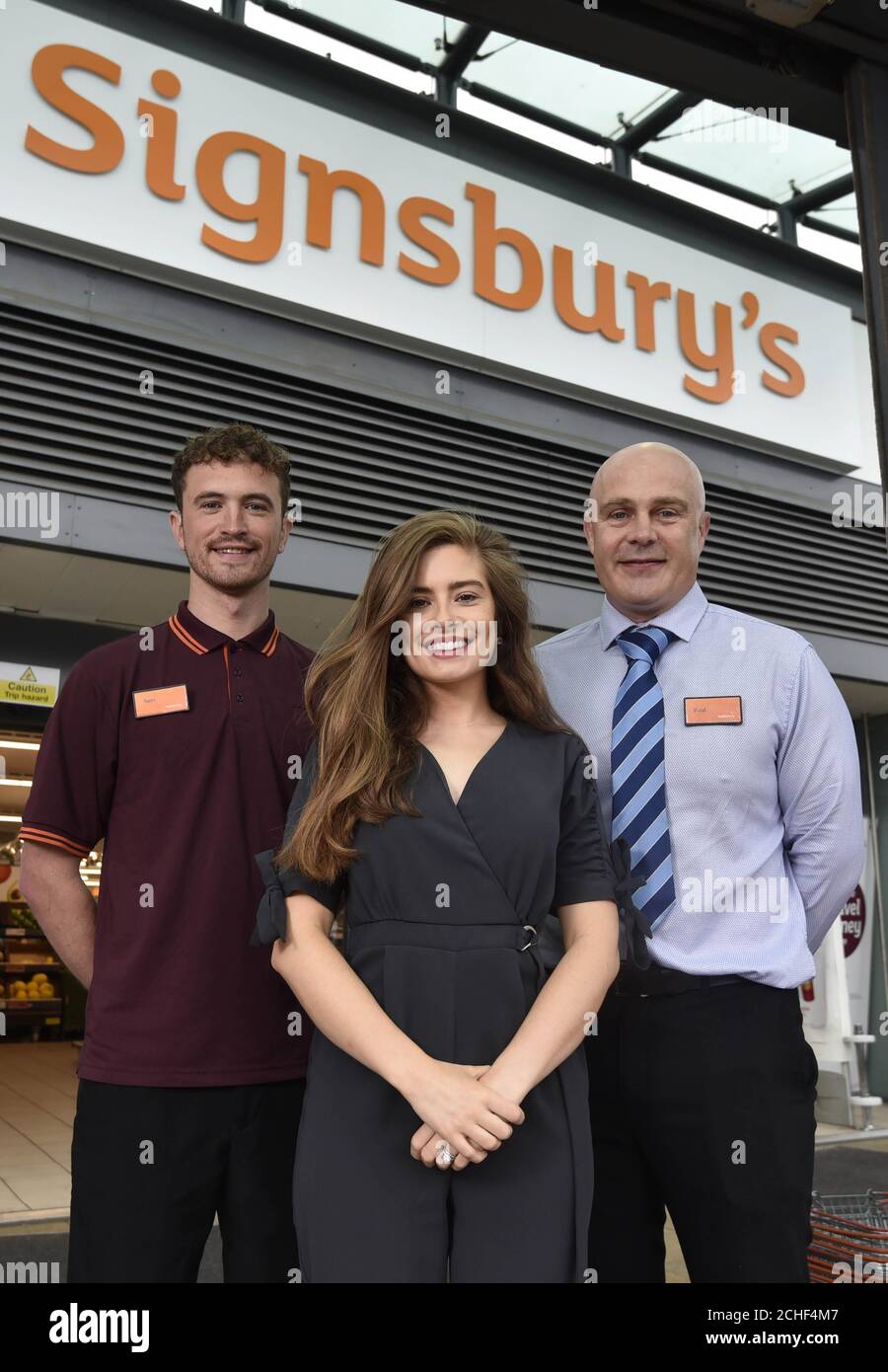 EDITORIAL USE ONLY Actress Rachel Shenton, who is an ambassador for the National Deaf Children's Society, Sainsbury???s colleague Sam Book, who is deaf, and Paul Robertson, general manager, unveils the new store front, as Sainsbury???s in Bath has transformed into Signsbury???s for the weekend.  Stock Photo
