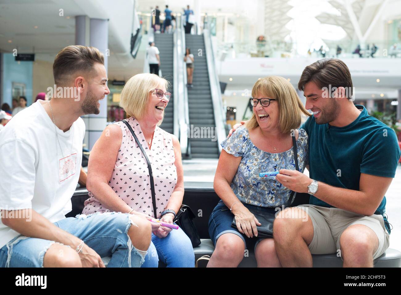 Former Love Island contestants Chris Hughes and Jack Fincham compliment members of the public at Westfield London in association with Mentos to celebrate National Friendship Day, which is on Tuesday July 30 Stock Photo