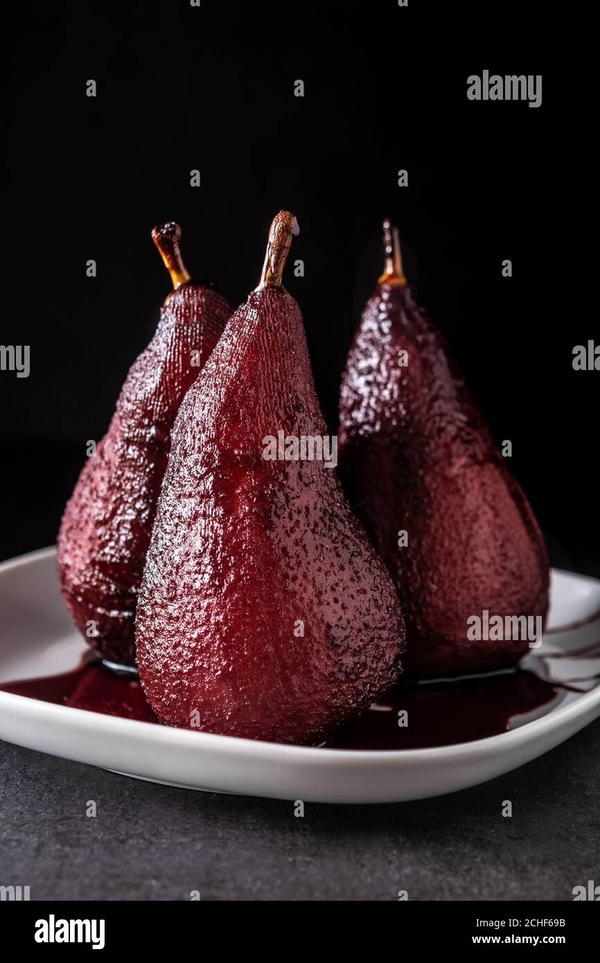 Poached pears in red wine on black background Stock Photo