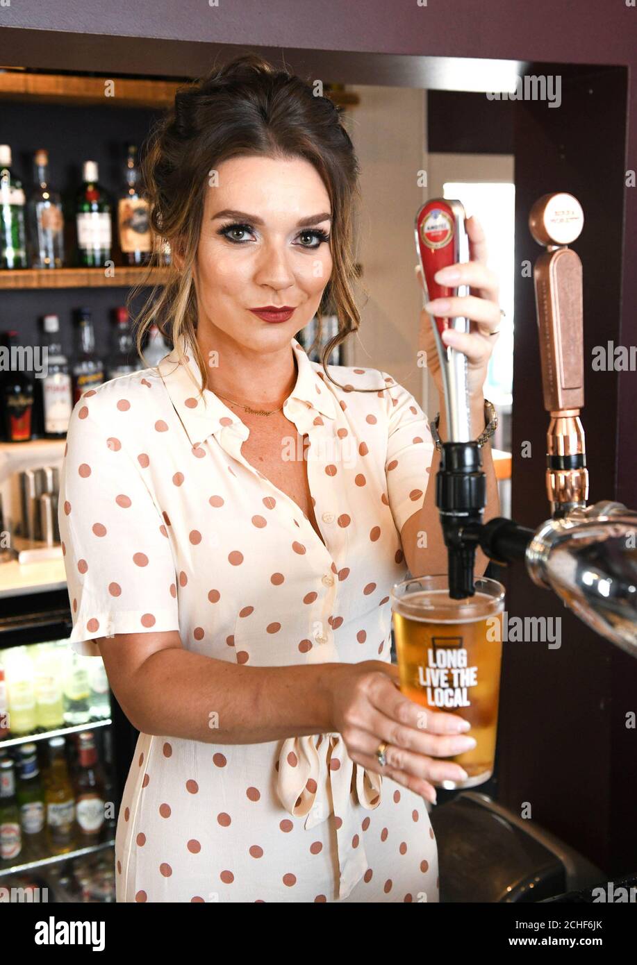 EDITORIAL USE ONLY Publican Candice Brown serves customers at her pub 'The Green Man' in Eversholt for the Long Live The Local campaign. Stock Photo