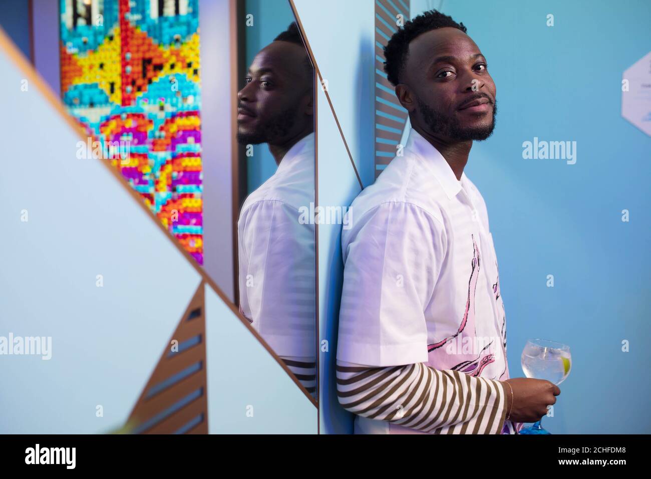Yinka Ilori with his artwork at the Bombay Sapphire Stir Creativity Lounge at Frieze London, where the gin brand is launching a new Artificial Intelligence art collection in collaboration with artist Yinka Ilori. Stock Photo