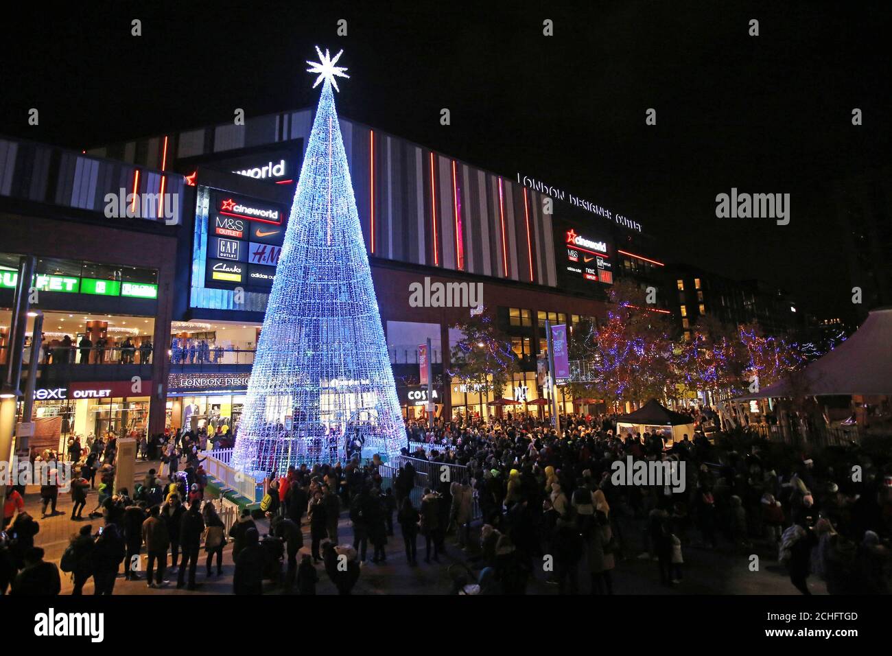EDITORIAL USE ONLY Crowds gather around 'The Hopeful Tree', which is the tallest LED Christmas tree ever built in London and features 'Murmuration of Hopes' by architectural designer Elyne Legarnisson, at the launch of Wembley Park???s 'Winterfest' Festival in London. Stock Photo