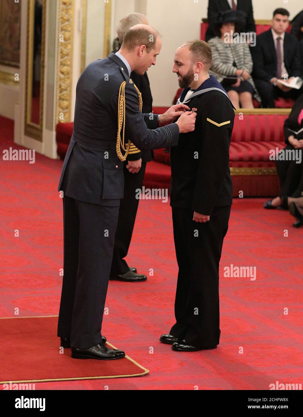 Air Engineering Technician Matthew Gallimore, Royal Navy, is made an MBE (Member of the Order of the British Empire) by the Duke of Cambridge at Buckingham Palace. Later, after the Investiture ceremony had concluded, Matthew proposed to his girlfriend, Adele, in the palace's Quadrangle. Stock Photo